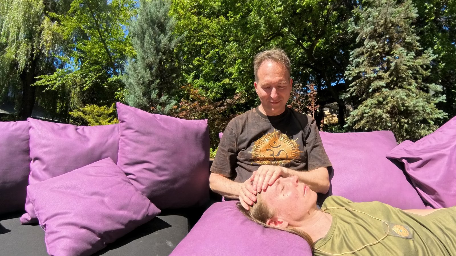 Dr. Mark Hosak behandelt Eileen liegend · Hand auf Kopf · klassische Reiki-Position