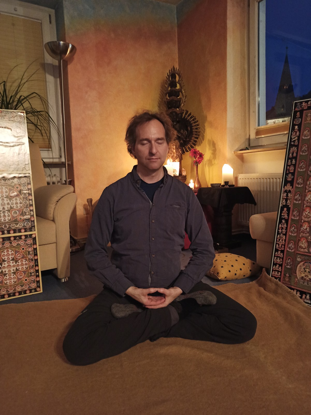 Dr. Mark Hosak liegend vor einer Kannon-Statue · stille Heilungspraxis im Bezug zum Medizin-Buddha
