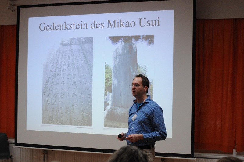 Dr. Mark Hosak hält einen Vortrag über den Gedenkstein des Mikao Usui mit Originalfoto und Inschrift